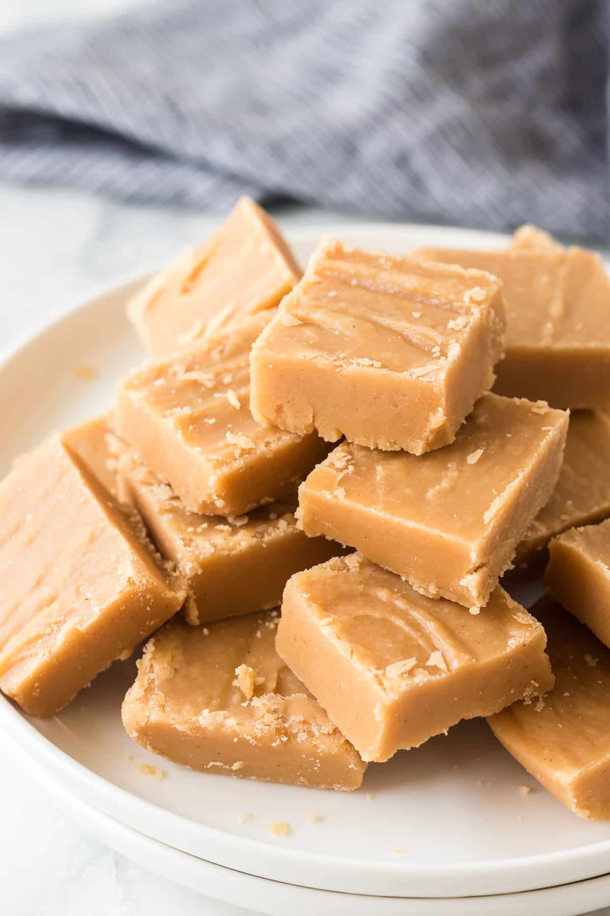 peanut butter fudge pieces stacked on a plate